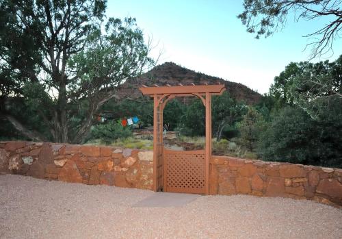 a wooden gate in a stone wall with a fence at Cathedral Casita at Sedona Cathedral Hideaway LLC in Sedona