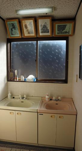 a bathroom with a sink and a window at Minpaku Hanaya in Nozawa Onsen