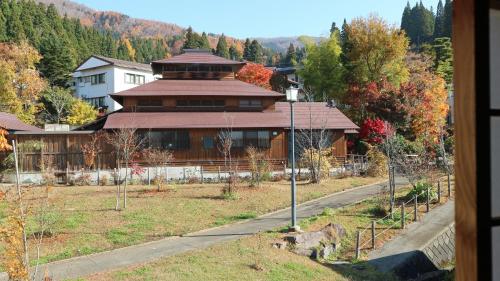 a house on a hill with a road in front of it at Minpaku Hanaya in Nozawa Onsen
