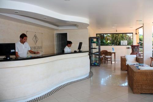 two people standing at a counter in a restaurant at Rio Búzios Beach Hotel in Búzios