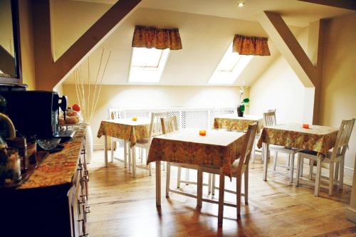 a dining room with tables and chairs and windows at Hotel Zorza in Namysłów