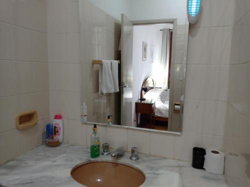 a bathroom with a sink and a mirror at Casa Rosário Centro de Amparo in Amparo