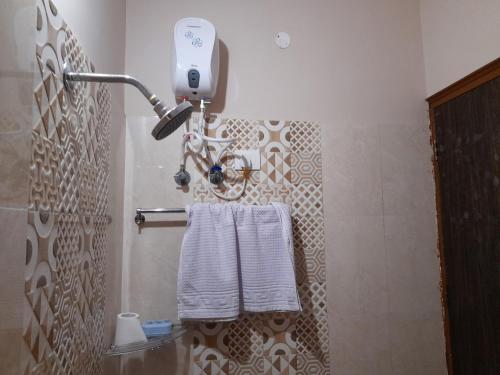 a bathroom with white towels hanging on a wall at Govind Niwas Home Stay in Gwalior
