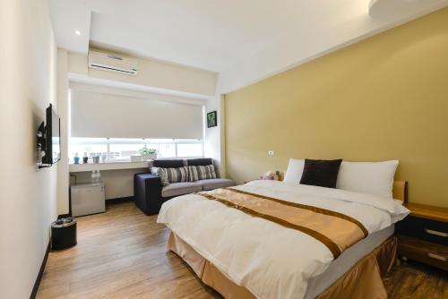 237 Hotel في كاوشيونغ: غرفة نوم بسرير كبير وأريكة
