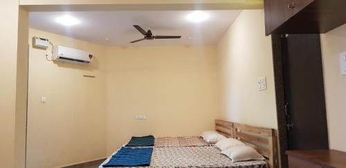 a room with a bed and a ceiling fan at Godwill Kimo Guest house Seraulim in Madgaon