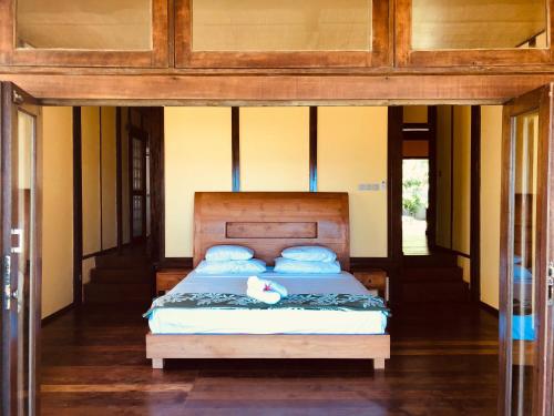 a bedroom with a bed with blue pillows at Bora Bora waterfront sunrise villa in Bora Bora