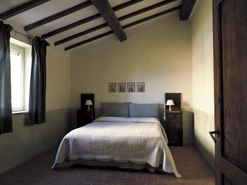 a bedroom with a bed and two night stands and a window at Villa Le Terme in San Casciano dei Bagni