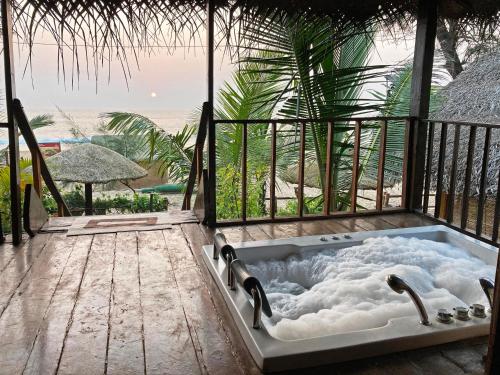 a jacuzzi tub on a deck with a view at Agonda Villas in Agonda