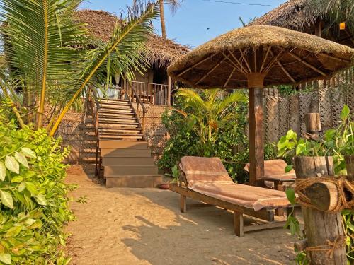 a chair and an umbrella next to a building at Agonda Villas in Agonda
