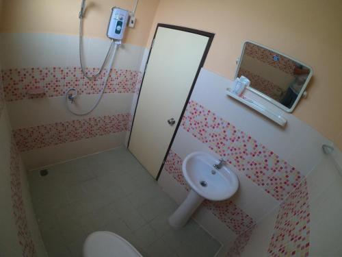 La salle de bains est pourvue de toilettes, d'un lavabo et d'un miroir. dans l'établissement The One, à Phayao