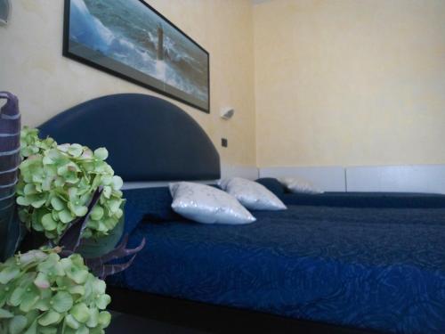 a bedroom with a blue bed with pillows and a plant at Hotel Eden in Bellaria-Igea Marina