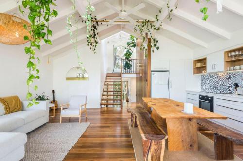 a kitchen and living room with a wooden table at The Oasis Apartments and Treetop Houses in Byron Bay