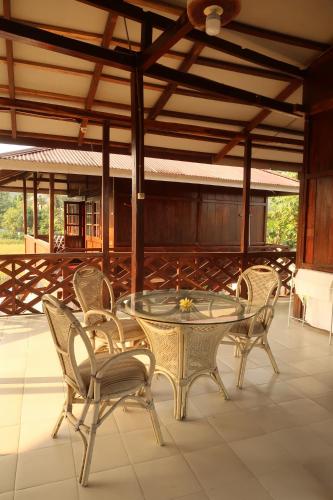 a glass table and chairs on a patio at Arya's Surf Camp in Sukabumi
