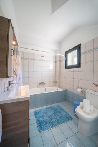 a bathroom with a tub and a toilet and a sink at Villa Hara in Agia Effimia