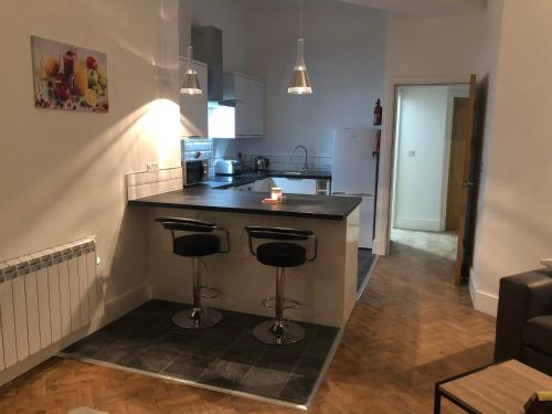 a kitchen with a counter and two bar stools at King Edward House Flat 1 in Hull