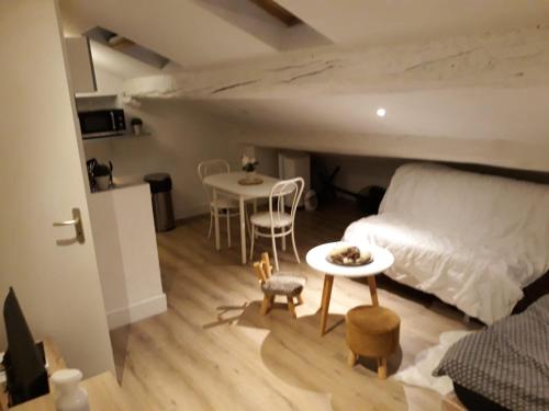 um quarto com uma cama, uma mesa e cadeiras em 5 Rue du Jeu de Paume Appartem em Valence