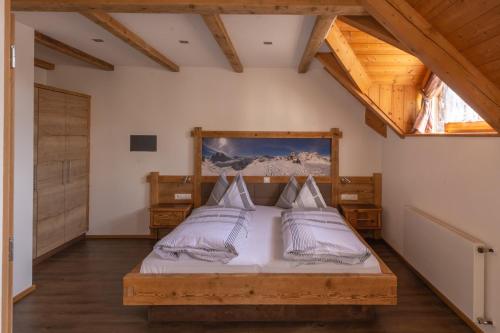 Schlafzimmer mit einem Bett mit weißer Bettwäsche und Kissen in der Unterkunft Residence Rogger in Toblach