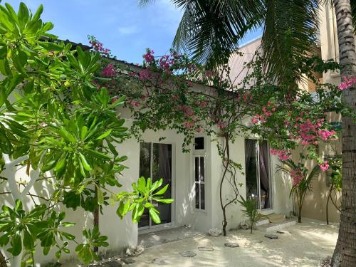 a white building with pink flowers on it at Kahanbu Ocean View in Thulusdhoo