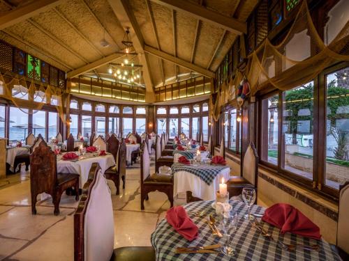 a dining room with tables and chairs and windows at Sunny Days El Palacio Resort & Spa in Hurghada