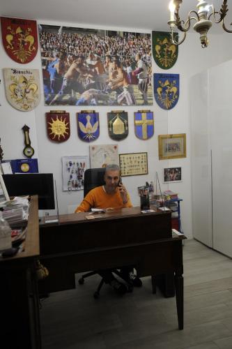 a man sitting at a desk in an office at B&B Calcio Storico in Florence