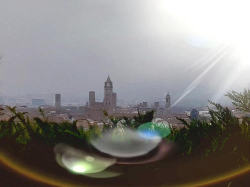 a view of a city with the sun in the background at La Duchessa in Alba