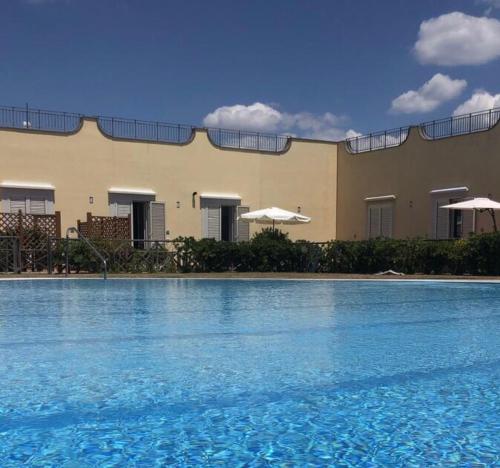 a large swimming pool in front of a building at Pia Beach House in Bacoli