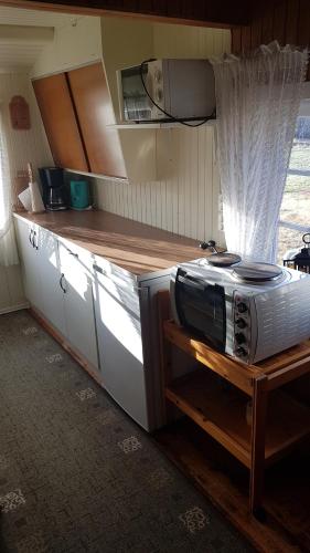 a small kitchen with a microwave on a counter at Gammelstuggu in Bjorli