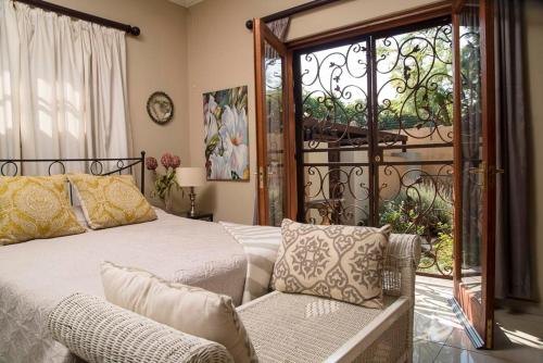 a bedroom with a bed and a couch and a window at The Lemon Tree Self- Catering in Johannesburg