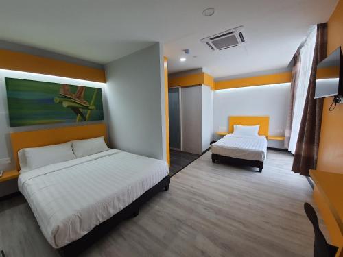 a hotel room with two beds and a chair at PARADIAN HOTEL in Seremban