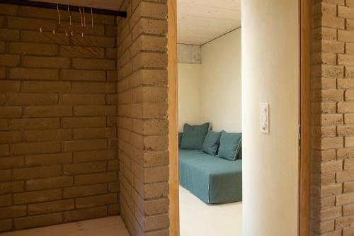 a couch in a room with a brick wall at Gästehaus Belle5 in Bellerive