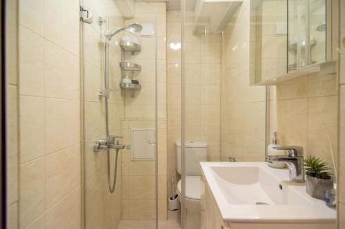 een badkamer met een douche, een wastafel en een toilet bij LunApart in Varna
