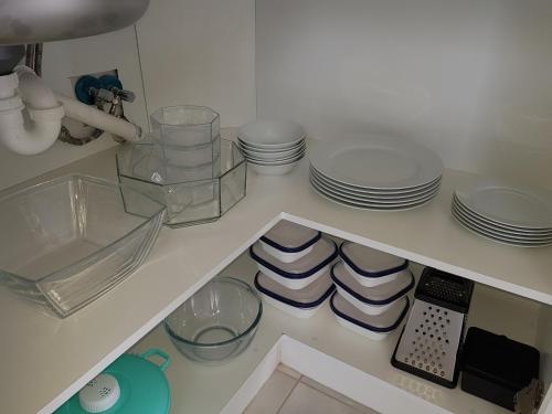 a kitchen with plates and dishes on a shelf at The Loft on Malmok in Paternoster