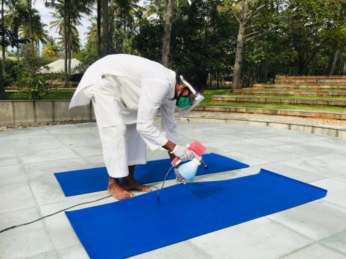 a man is playing golf on a blue mat at Shreyas Retreat in Nelamangala