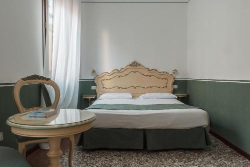 a small bedroom with a bed and a table at Ca' San Trovaso - 6 Rooms in Venice