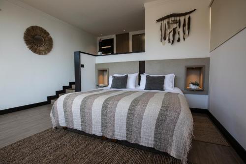 a bedroom with a large bed and a mirror at Pura Lodge in Concepción