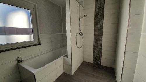 a bathroom with a shower and a bath tub at Schnetter Hummel, Apartment 1 in Masserberg