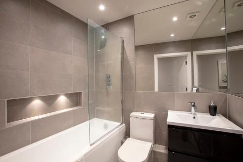 a bathroom with a toilet and a sink and a shower at Hampden Apartments - The Edward in Windsor