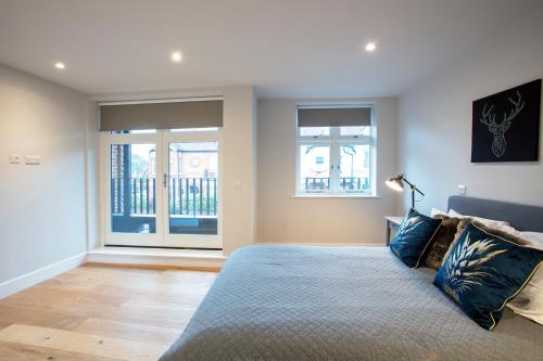 um quarto com uma cama e duas janelas em Hampden Apartments - The Edward em Windsor