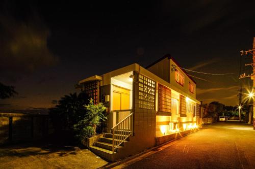 a building with lights on the side of it at night at ITOMAN SEA pension OHDO #MIM in Ōdo