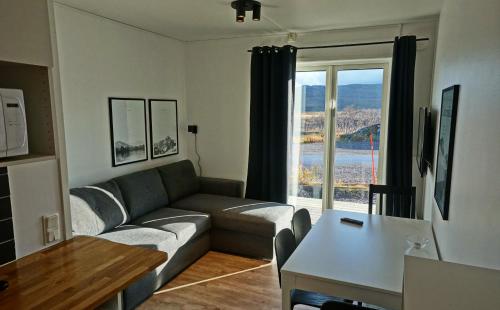 een woonkamer met een bank en een tafel bij Arctic Lodge in Riksgränsen
