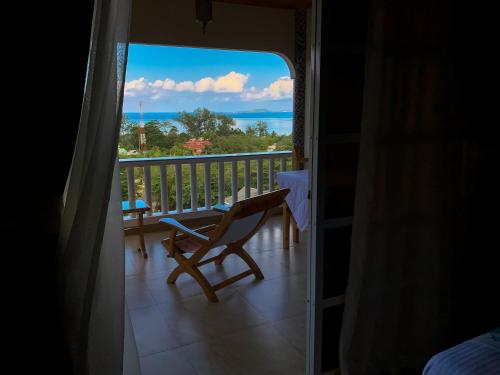 a room with a view of the ocean from a balcony at Exotic Guest House in Anse Possession