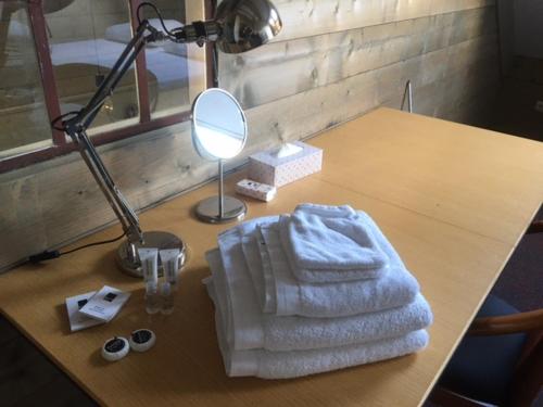 a table with a white blanket and a lamp and a mirror at Vakantiehuis bij Bedaf in Uden