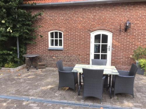a table and chairs in front of a brick building at Vakantiehuis bij Bedaf in Uden