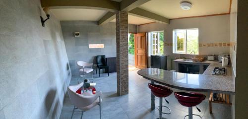 a kitchen with a counter and stools in a room at Exotic Guest House in Praslin