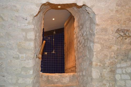 an opening in a stone wall with a wooden door at Gîte Manoir in Bouloc