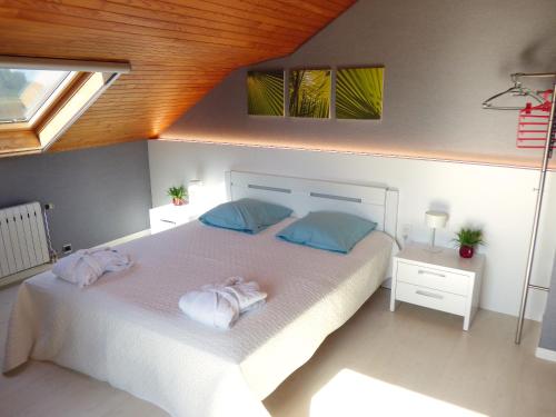 um quarto com uma cama branca com duas toalhas em B&B Le Jardin d'Epicure em Olne