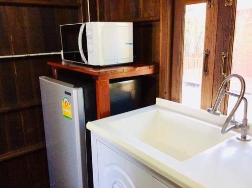 cocina con fregadero blanco y microondas en The Green Vale B&B, en Ban Na Chaliang
