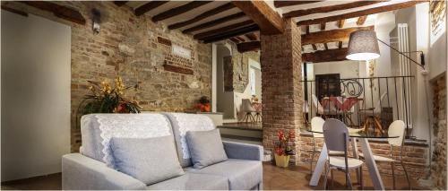 sala de estar con silla blanca y mesa en Il Giardino sul Tetto B&B, en Guarene