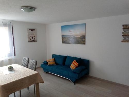 ein Wohnzimmer mit einem blauen Sofa und einem Tisch in der Unterkunft da ANGELINA in Tuttlingen