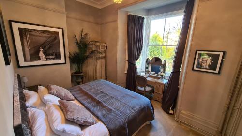 a bedroom with a bed and a window at Court House Apartment in Cheltenham